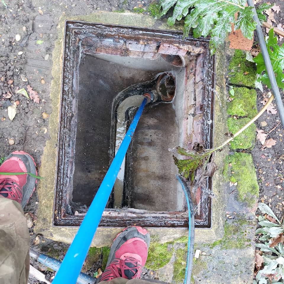 Manhole cover removed in Cobham to Unblock Drain